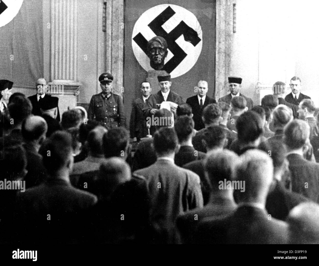 (dpa files) - Roland Freisler (C), the President of the 'National Socialist People's Court' (Volksgerichtshof, VGH), reads out the verdict against the eight suspects of the assassination attempt on Hitler of 20 July 1944, the so-called July Plot, at the court in Berlin, 8 August 1944. In the background behind Freisler a bust of Adolf Hitler can be seen, and a swastica with a hidden Stock Photo