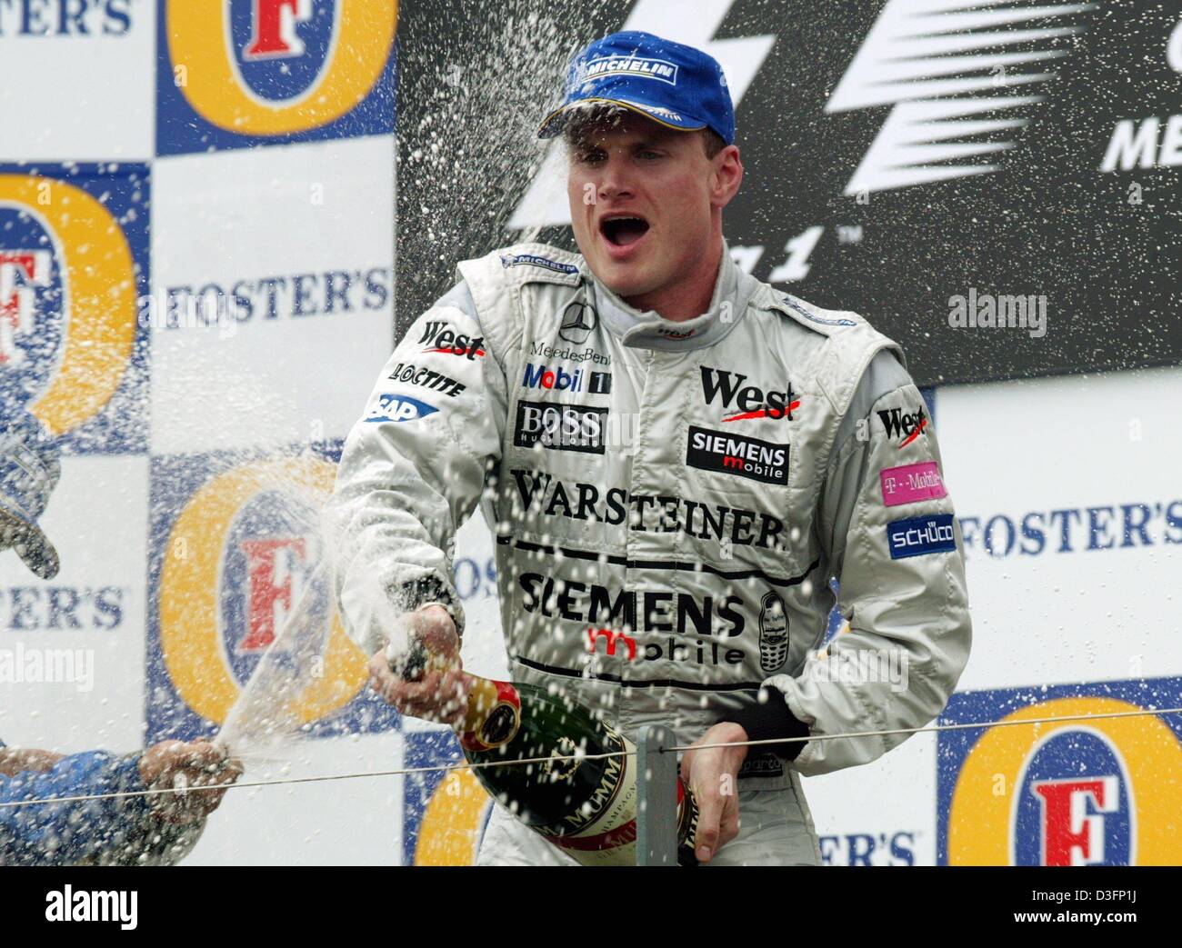 (dpa) - Scottish formula one pilot David Coulthard of McLaren-Mercedes squirts champagne in Melbourne, Australia, 9 March 2003. He wins the year's first race of the formula one for the Grand Prix of Australia and celebrates his 13th victory in his 142nd formula one race. Stock Photo