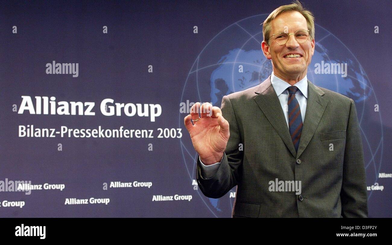 (dpa) - Michael Diekmann, new CEO of the Allianz AG, the financial services and insurance provider, stands in front of the company logo and smiles during a press conference in Munich, Germany, 20 March 2003. Diekmann continues the company policy of providing integrated financial services by holding on to the lossy Dresdner Bank. The Allianz AG wants to raise new capital in billions Stock Photo