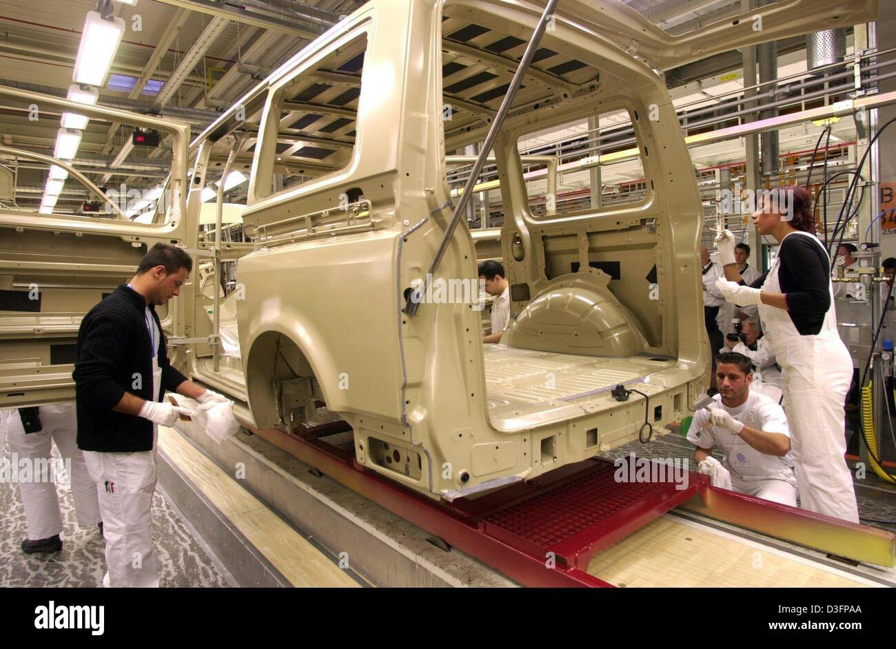 (dpa) - Volkswagen employees work on the new T5 Volkswagen van at the VW production site in Hanover, Germany, 6 March 2003. Recession and high invesments in 2002 have caused a collapse of profit of up to 14.2 per cent in the business of the VW subsidiary. Stock Photo