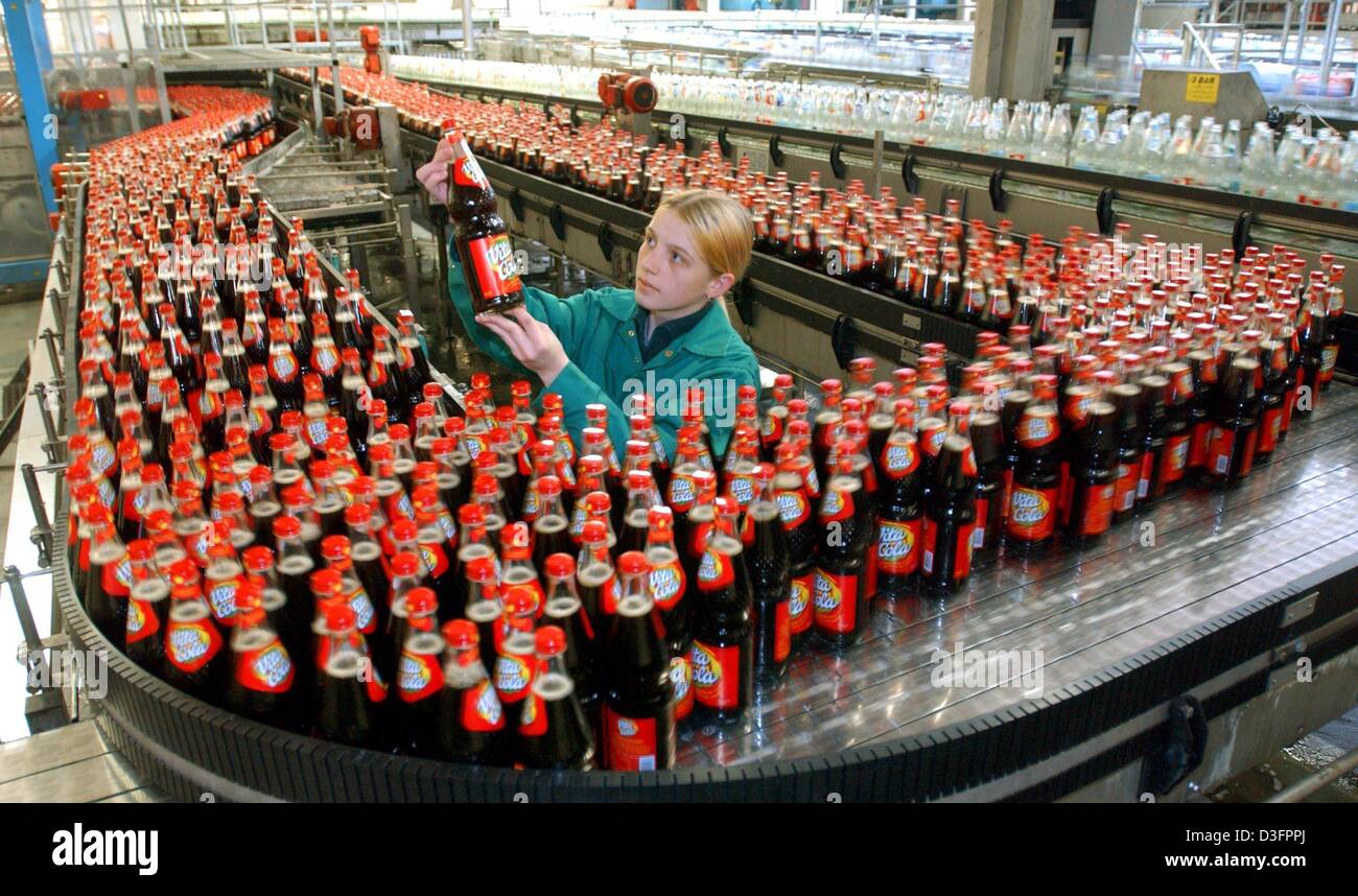 (dpa) - A worker checks 'Vita-Cola' coke bottles at the production site of the soft drinks and water company Thuringia Waldquell Mineralbrunnen GmbH in Schmalkalden, Germany, 14 March 2003. The new assembly line is able to produce and fill 20,000 half-litre PET bottles per hour. Vita Cola is a cult drink in the eastern part of Germany. In 2002, Thuringia Waldquell was able to incre Stock Photo