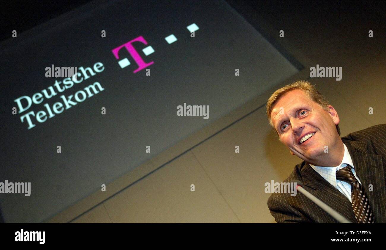 (dpa) - Kai-Uwe Ricke, CEO of the Deutsche Telekom AG, the German telecommunications company, smiles during a press conference with the company's logo projected in the background in Hanover, Germany, 10 March 2003. Kai-Uwe Ricke says that the 2002 business year had been one of the most difficult years in the company's history and also the worst in the history of the Germany economy Stock Photo