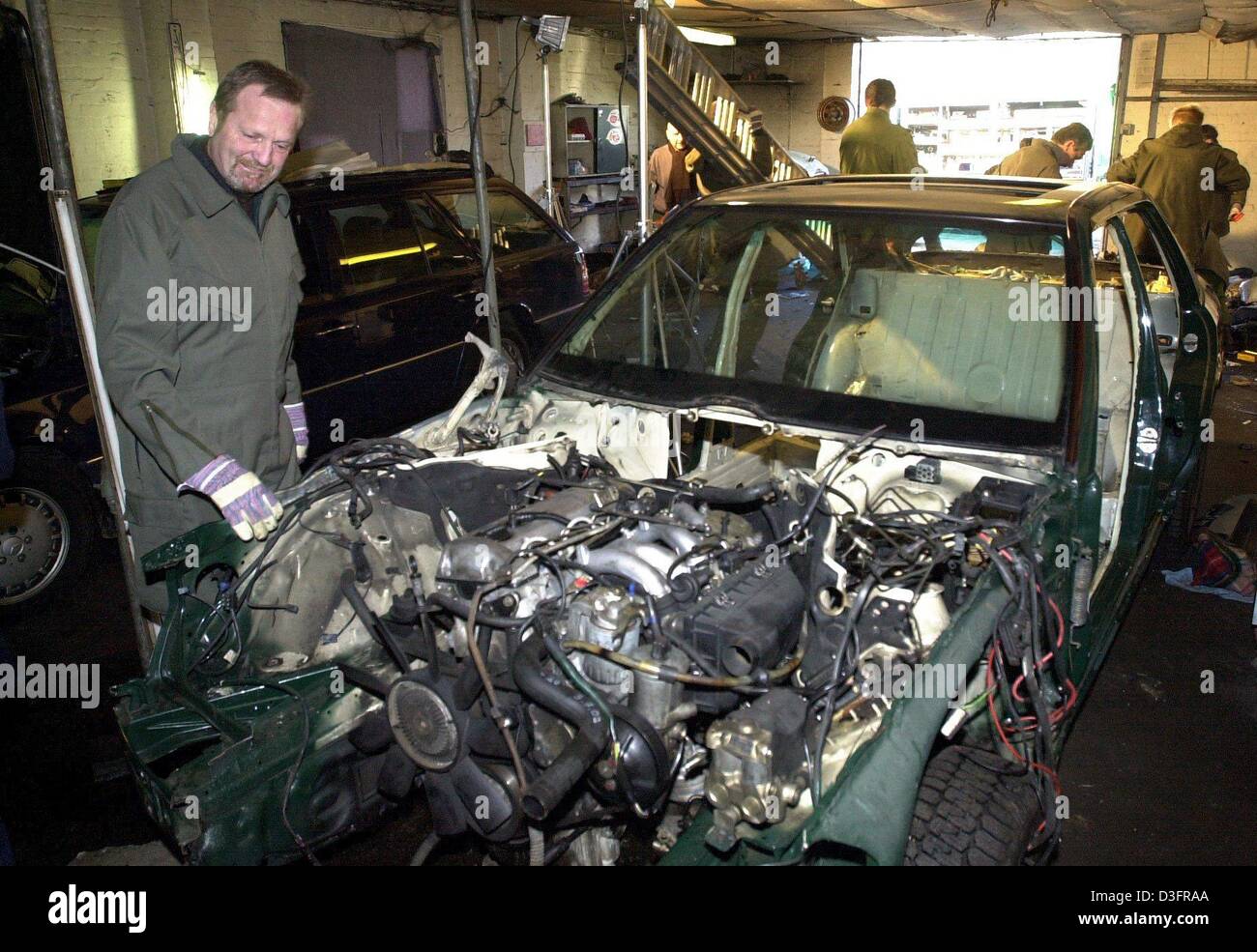 (dpa) - Police examine stolen, stripped down cars in a workshop on the premises of a closed down munitions factory in Quickborn, northern Germany, 26 February 2003.  An international ring of car thieves allegedly took apart stolen cars at the workshop and shipped the parts to Lithuania, where the cars were then reconstructed.  Police have already identified ten of the stolen vehicl Stock Photo