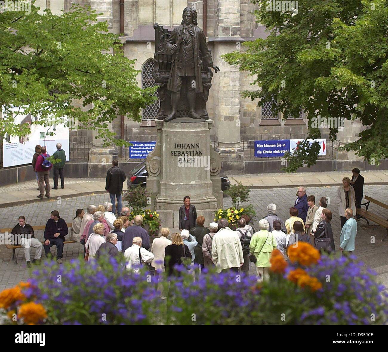 (dpa files) - Tourists look at the statue of German composer Johann Sebastian Bach in front of the St Thomas Church in Leipzig, eastern Germany, 20 July 2000. The statue was created in 1908 by Carl Seffner. Born on 21 March 1685 in the village of Eisenach to a musical family, Bach had his first major appointment in 1708 as organist at the ducal court at Weimar. This was followed by Stock Photo