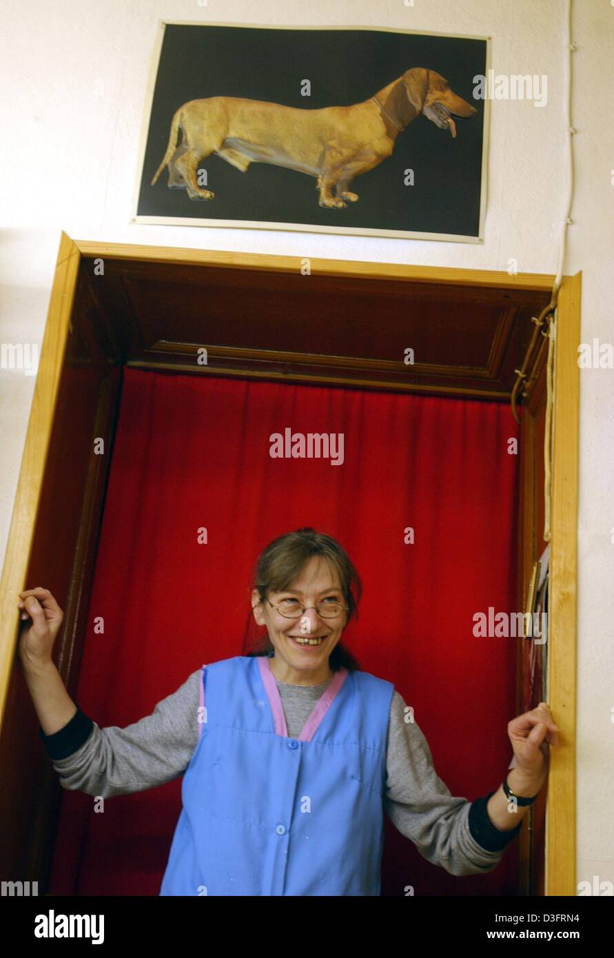 (dpa) - Christel Balfanz stands in the doorway and smiles at the beauty parlour for dogs 'Exquisit' in Berlin, 12 February 2003. The owner and dog beautician, Christel Balfanz has been running her shop since 1971. She receives an average of four to five dogs a day and charges 10 Euro per hour. Often, working people drop by in the morning and leave their dogs with her until they col Stock Photo
