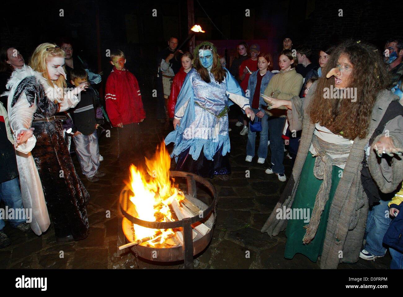 (dpa) - Women dressed up as witches dance around a fire celebrating Walpurgis Night in Brodenbach, western Germany, 1 May 2003. Walpurgis Night is an old pagan festival, which borrowed its name from Saint Walburga whose feast occurs on May Day. On this night witches are believed to ride on broomsticks and he-goats to places of old pagan sacrifices in the Harz Mountains, especially  Stock Photo