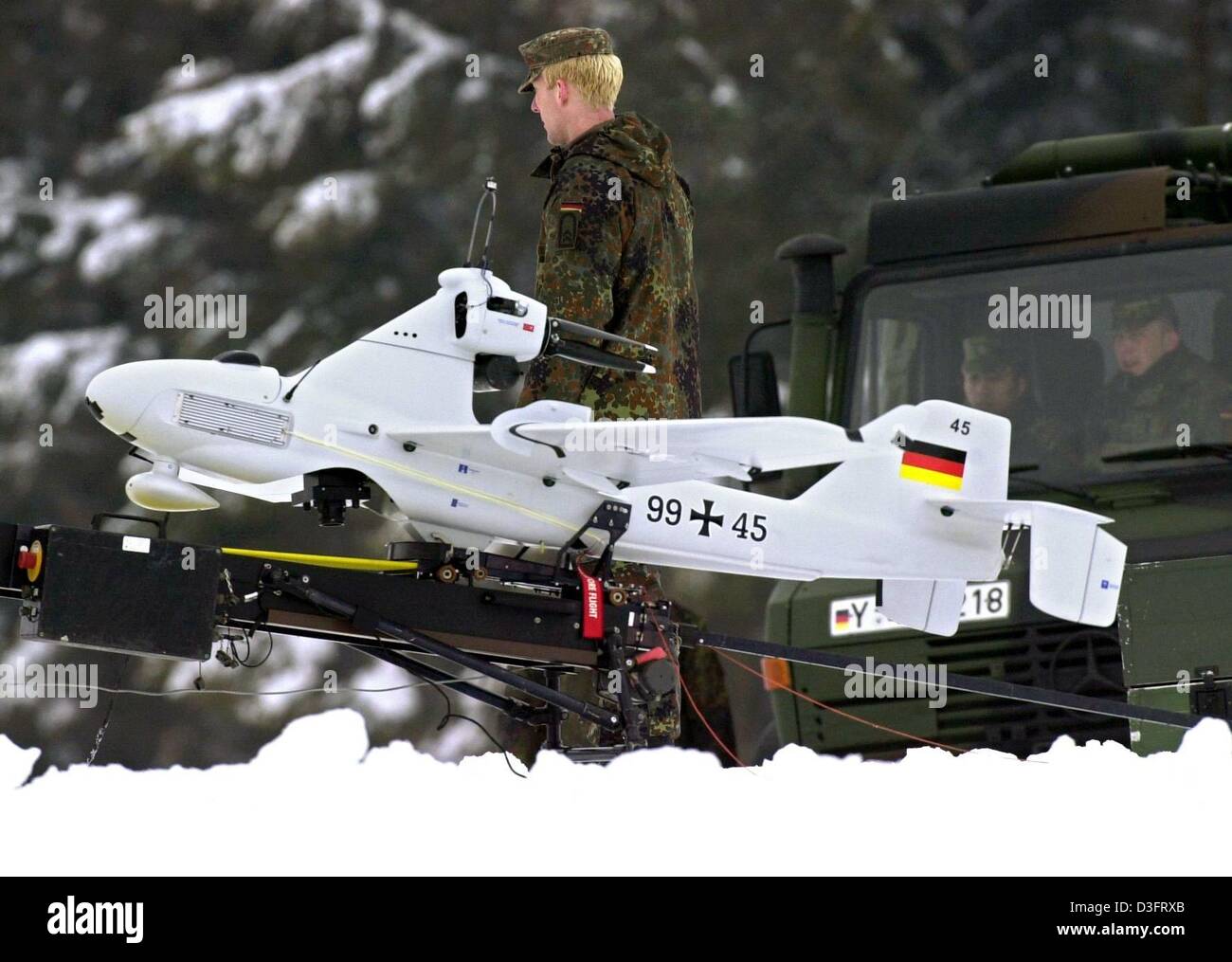 (dpa) - A soldier stands behind a Luna surveillance drone on the ground station of a military training area near Murnau, Germany, 11 February 2003. The Luna drone starts with a catapult take-off. It can be operated via an autopilot system and can film and send videos from a short distance without jeopardizing the lives of soldiers. The Luna drone was requested by the UN weapon insp Stock Photo