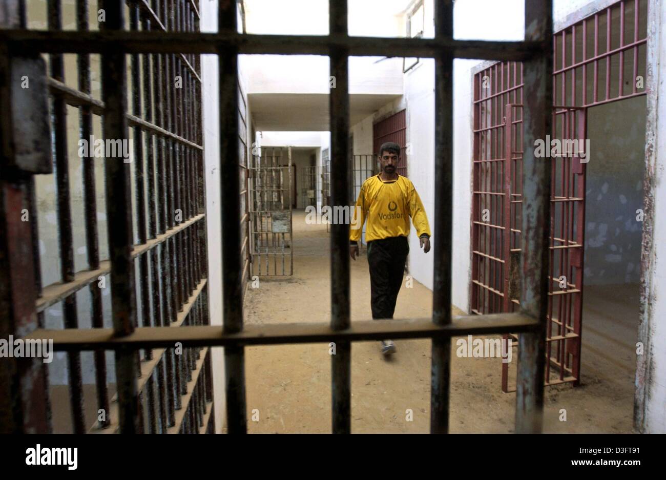 (dpa) -  A man walks along a corridor past rows of prison cells in the infamous Iraqi state security prison Abu Ghraib around 30 kilometres west of Baghdad, Iraq, 2 May 2003. Thousands of political prisoners had been tortured and executed in the prison. Stock Photo