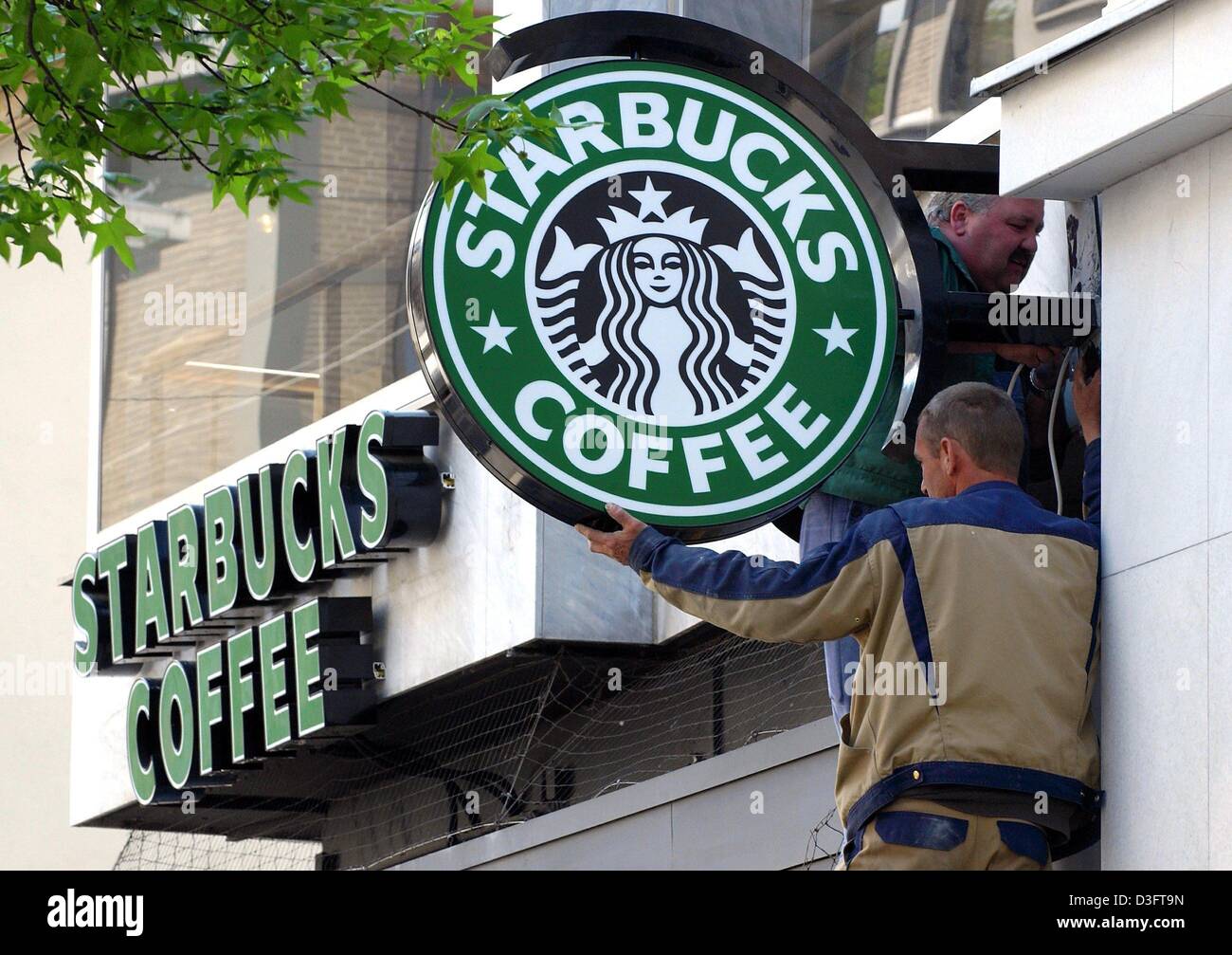 (dpa) Two men attach the logo of the American coffee house chain