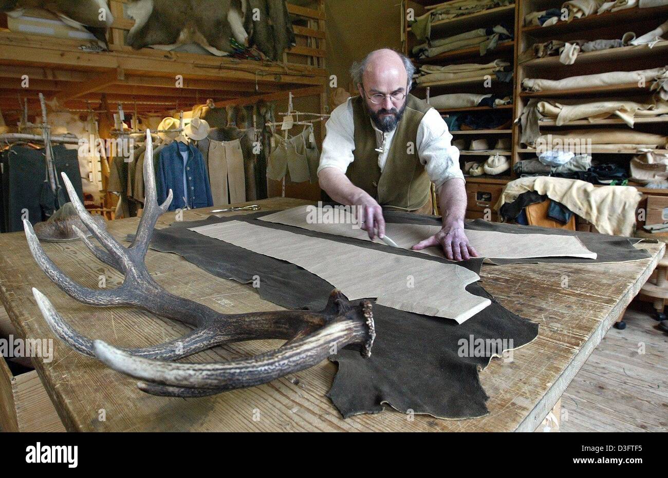 (dpa) Klaus Bensmann, leather tailor, cuts out a pattern for a pair