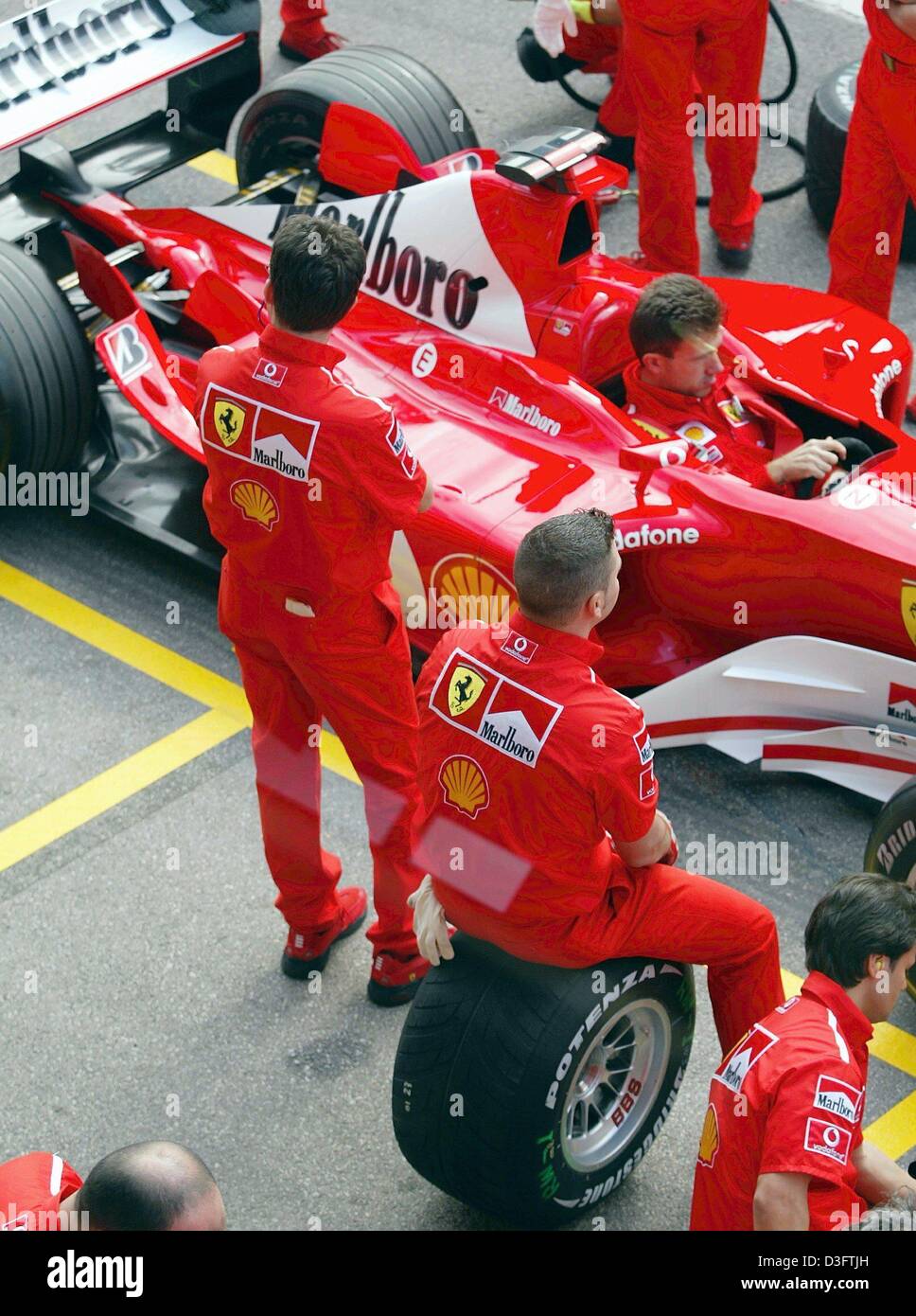 (dpa) - Ferrari mechanics stand in the pit line to rehearse a pit stop for the new Ferrari F2003-GA ahead of the first training at the Circuit de Catalunya near Barcelona, 2 May 2003. The car will make its race debut in the Spanish Formula One GP on 4 May 2003. Stock Photo