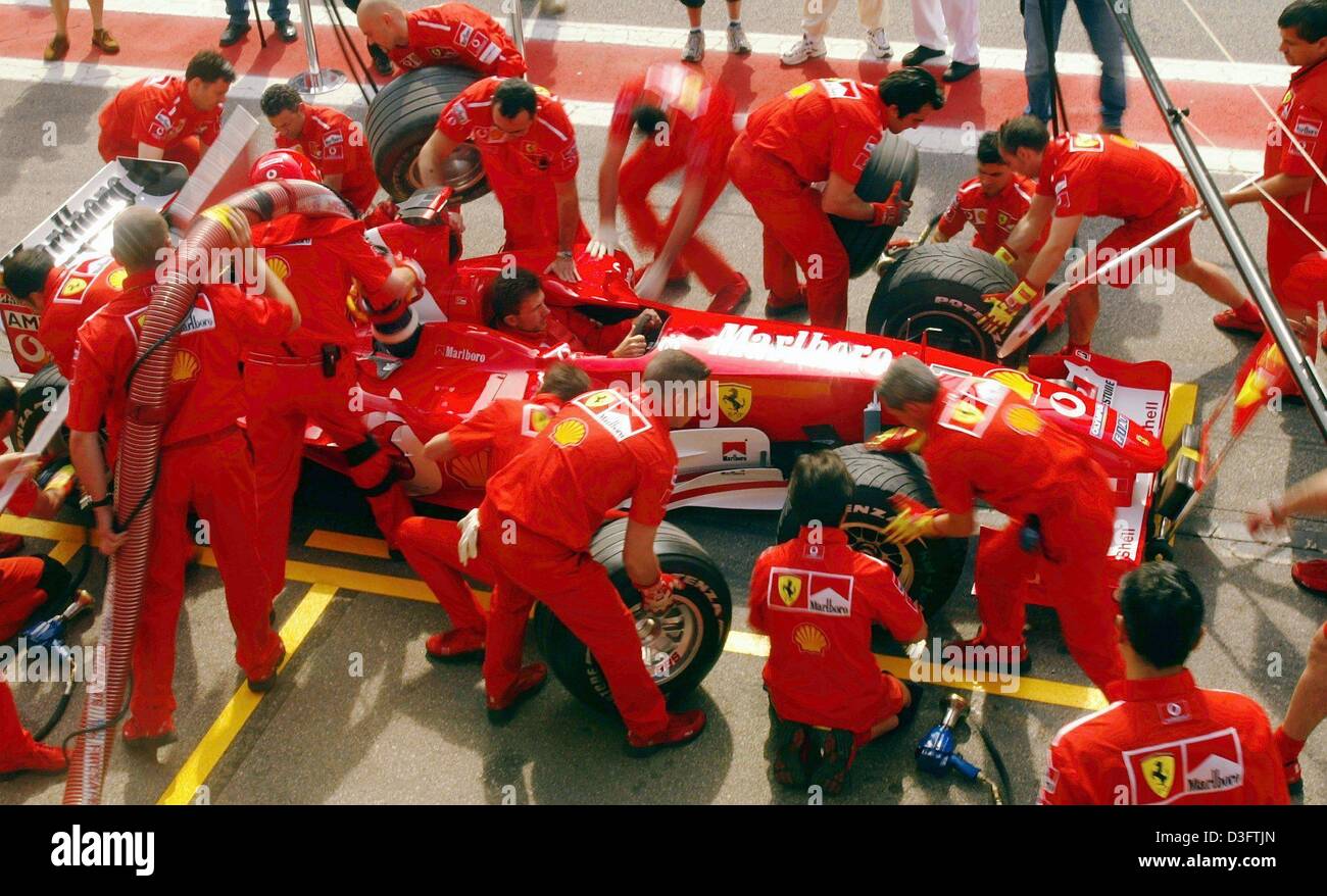 (dpa) - Ferrari mechanics stand in the pit line to rehearse a pit stop for the new Ferrari F2003-GA ahead of the first training at the Circuit de Catalunya near Barcelona, 2 May 2003. The car will make its race debut in the Spanish Formula One GP on 4 May 2003. Stock Photo