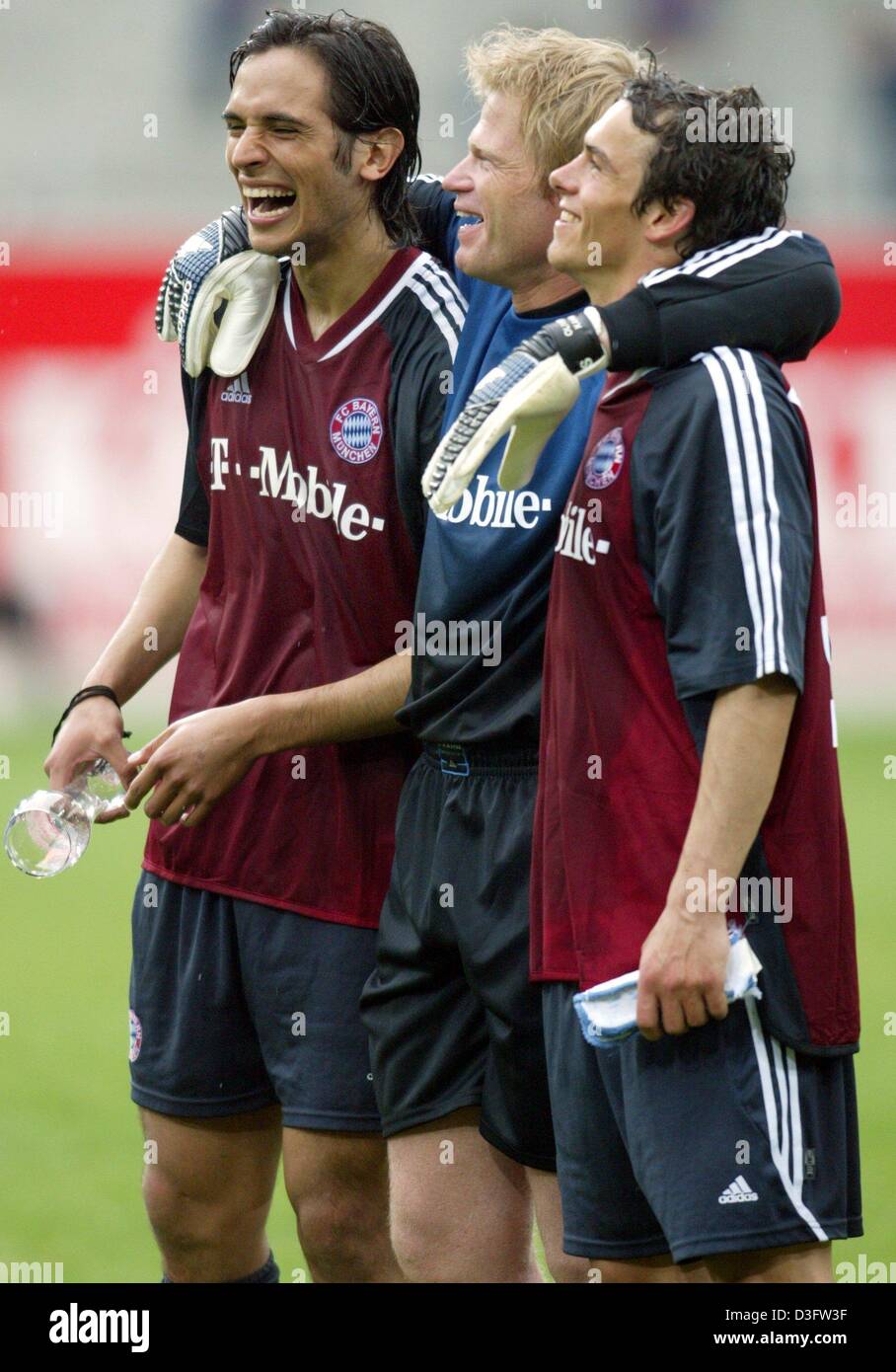 dpa) - Bayern's goalkeeper and team captain Oliver Kahn (C) lays his arms  around his team mates Roque Santa Cruz (L) and Markus Feulner after Bayern  Munich won the German championship title