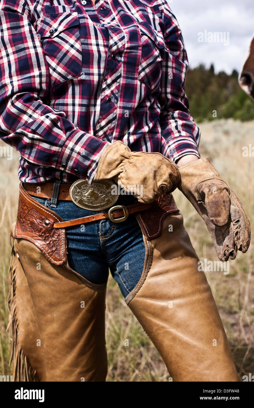 Cowgirl wrangler repairing fence, Montana, USA Stock Photo