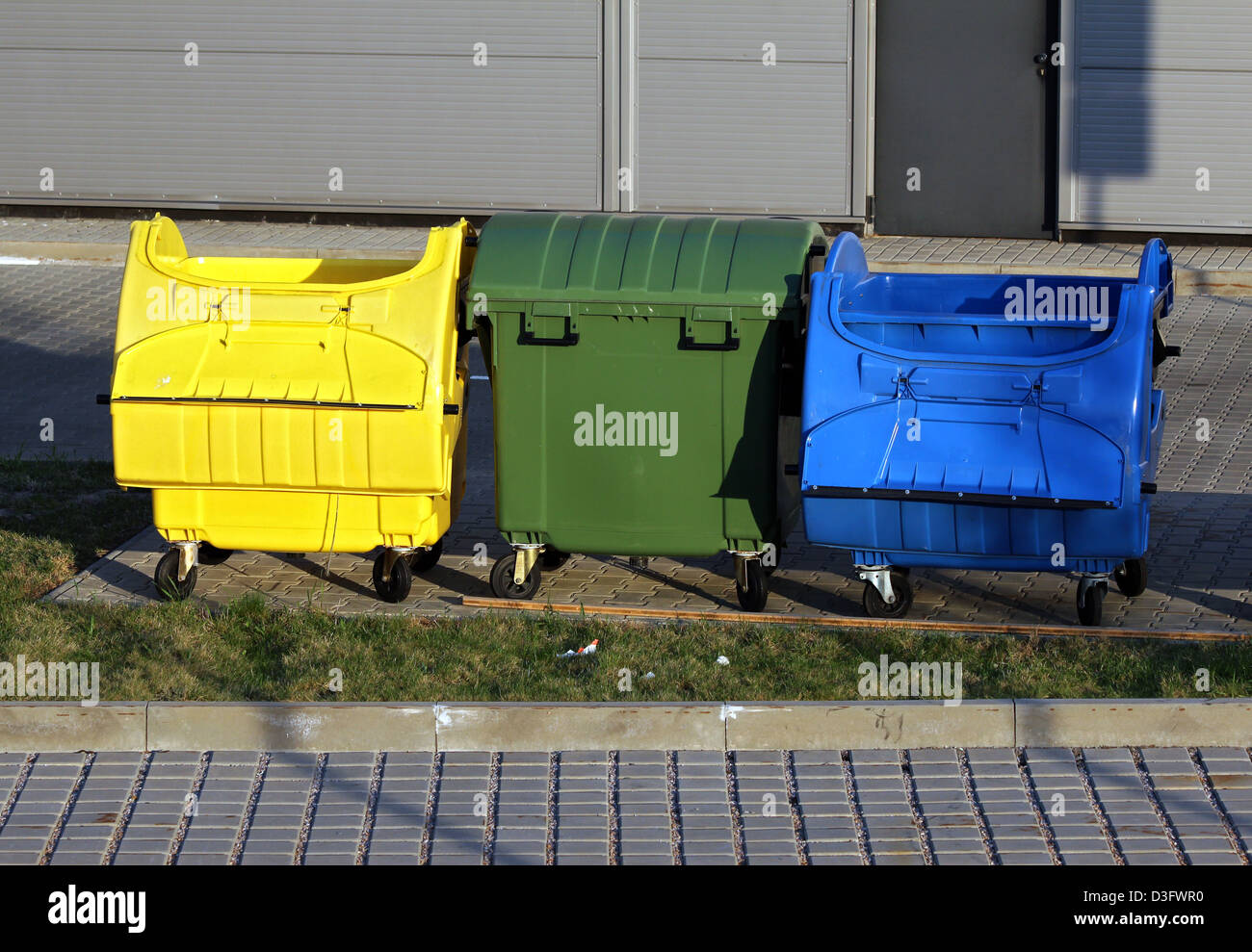 three plastic big trash recycling bins on the street Stock Photo Alamy