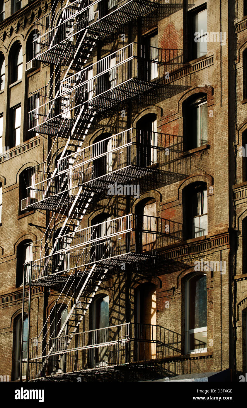 Fire escapes on the side of a high rise building in New York City in the late afternoon. Stock Photo