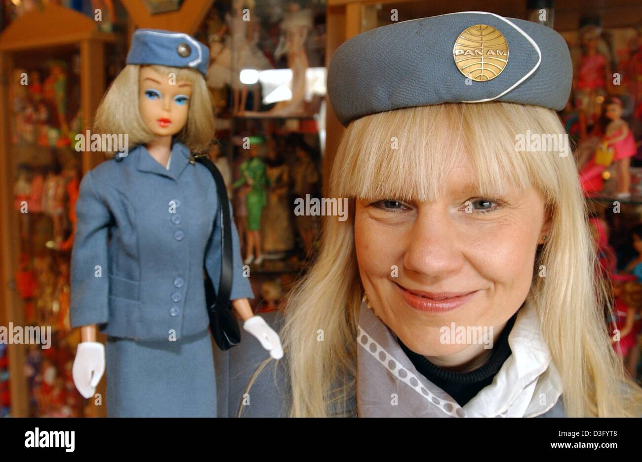 dpa) - Barbie doll 'doctor' Bettina Dorfmann, dressed as a flight attendant  to match the Barbie's costume, poses with one of her favorite  'resuscitated' Barbies in Duesseldorf, Germany, 30 January 2003. Dorfmann