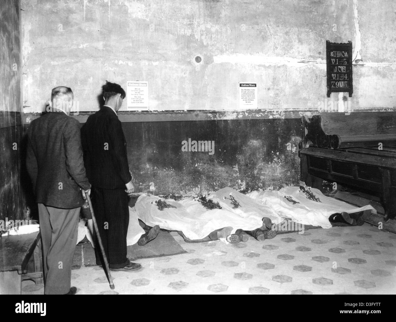 (dpa files) Dead bodies covered with white sheets lie on the floor of