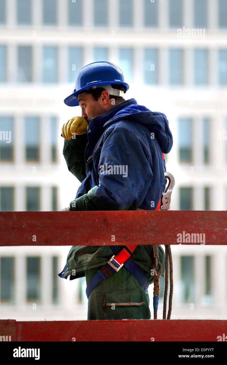 (dpa) - A construction worker is looking sceptically on a building site in Munich, 5 February 2003. Bad weather in winter is the reason for many layoffs in the building trade. As the federal employment office based in Nuremberg announced today, 4,623,100 unemployed were registered in January 2003 which is the highest number since the red-green government came into power in 1998. Th Stock Photo