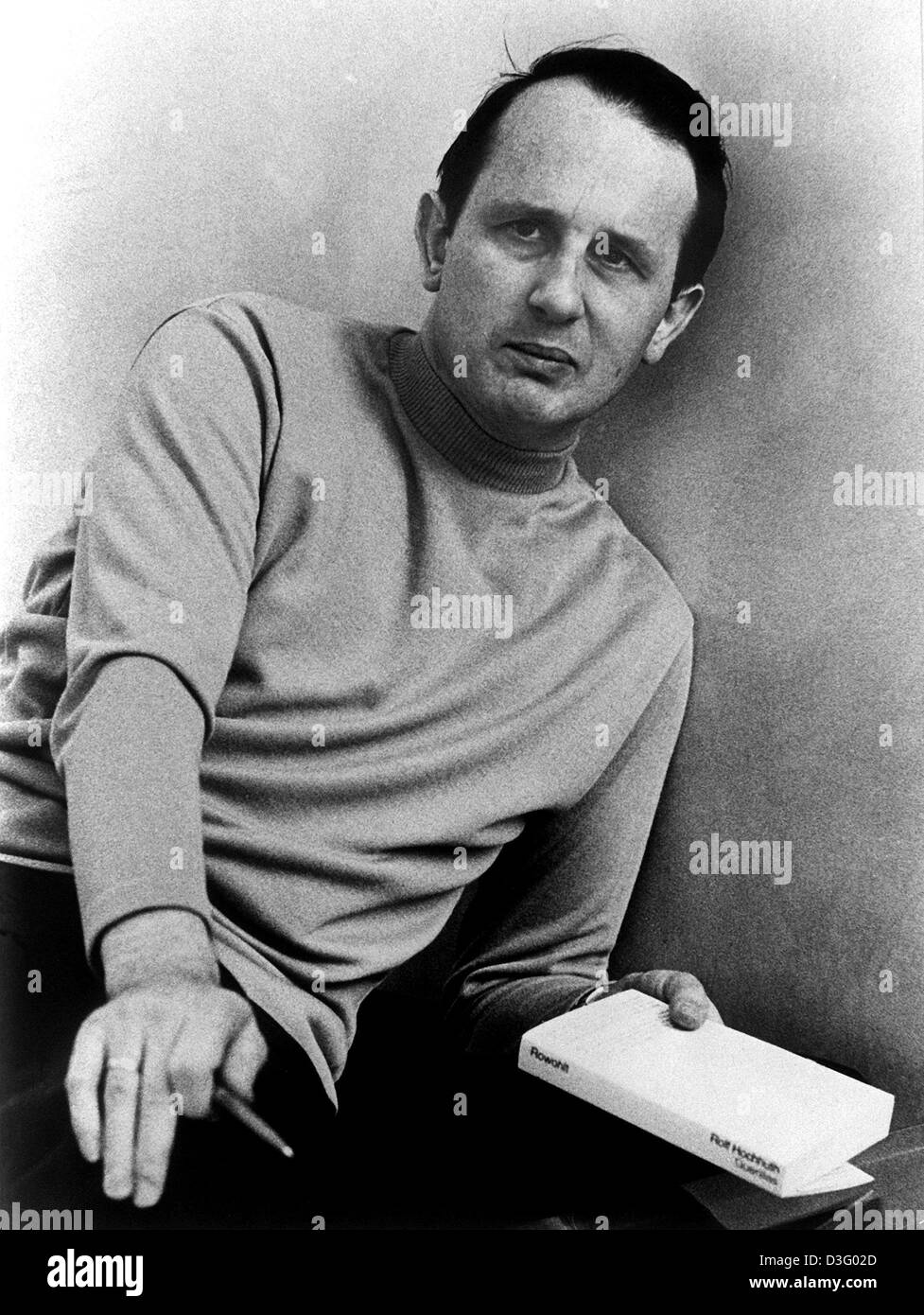 (dpa files) - German author Rolf Hochhuth is posing with his new book 'Guerillas', Stuttgart, 14 May 1970. The play had its world premiere on stage in Stuttgart on 15 May 1970. It is about the preparation of a coup d'etat in the USA. Hochhuth is best known for his drama 'The Substitute' ('Der Stellvertreter') which caused great controversy in the early 1960s as it deals with ties b Stock Photo