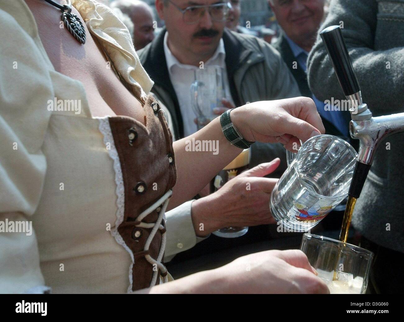 (dpa) - Beer is filled into beer glasses at the beer fountain in Munich, Germany, 23 April 2003. 23 April, the day of the beer, marks the beginning of the Bavarian beer week. Until 30 April, exhibitions, seminars and games about and with beer are offered by breweries, restaurants and tourism associations. Stock Photo