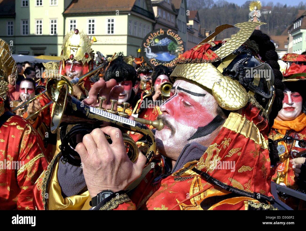 (dpa) - Carnival enthusiasts dressed up in Japanese costumes play Guggen music as they march through the streets of Schwaebisch Gmuend, southern Germany, 22 February 2003. 'Gugaaggeri Musig' is originally a characteristic feature of the Swiss carnival which is cultivated by several groups and has become well known far beyond the country. It consists of different instruments, includ Stock Photo