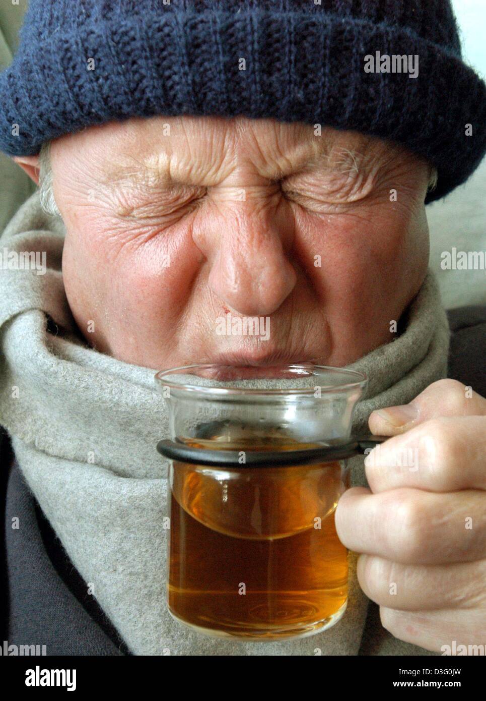 (dpa) - A man sick with the flu pulls a face as he takes a sip of herbal tea in Straubing, southern Germany, 20 February 2003.  According to medical experts, flu season should achieve its peak level in two weeks' time in Germany. Stock Photo