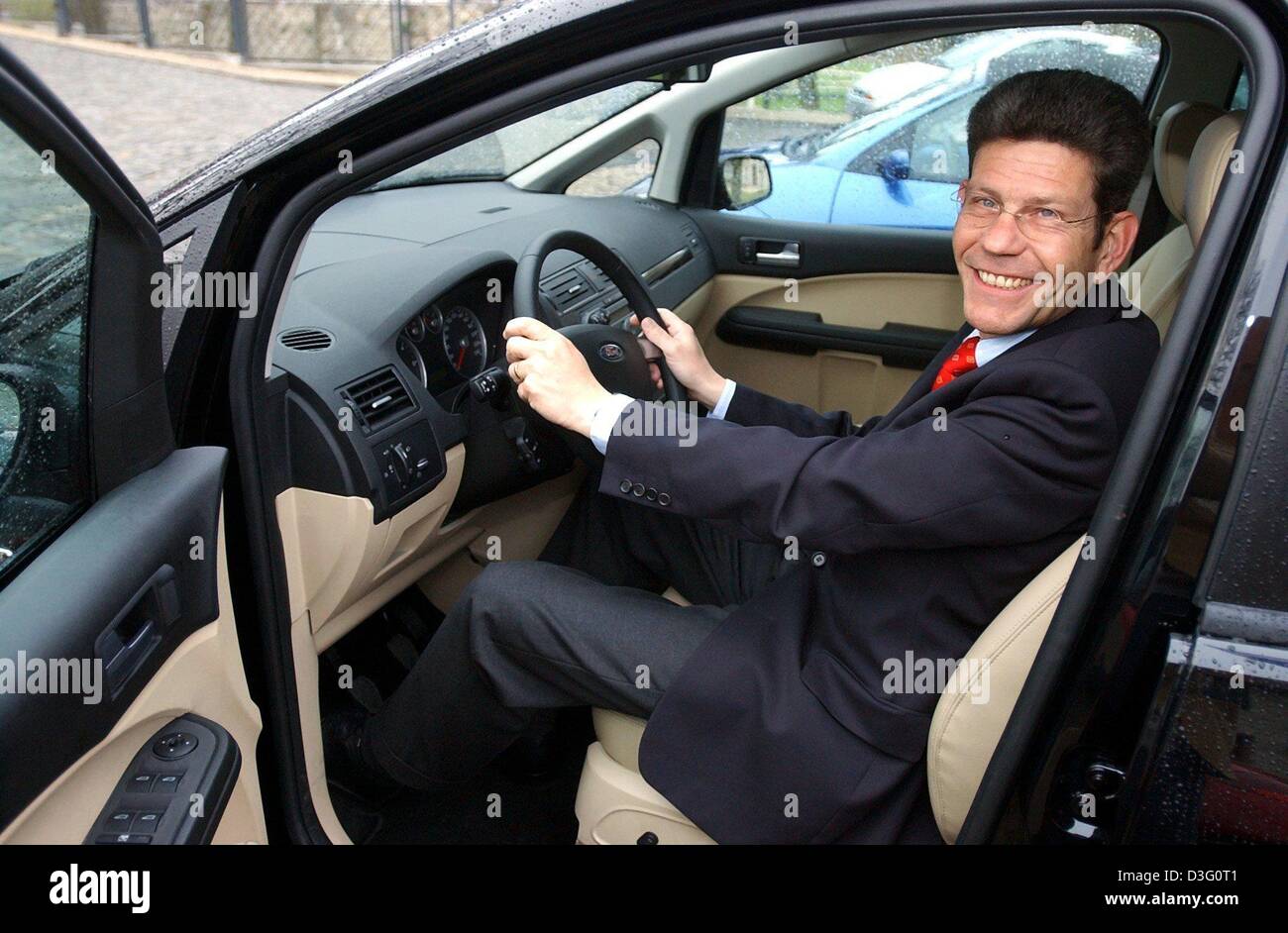 (dpa) - Bernhard Mattes, chairman of Ford AG, car manufacturer, sits in the driver's seat of a Focus C-Max and smiles in Schkopau, Germany, 3 April 2003. The model Ford Focus C-Max. will be introduced for the first time during the AMI (Auto Messe International) car exhibition fair in Leipzig. More than 415 exhibitor from 16 countries present the latest developments on cars, car app Stock Photo