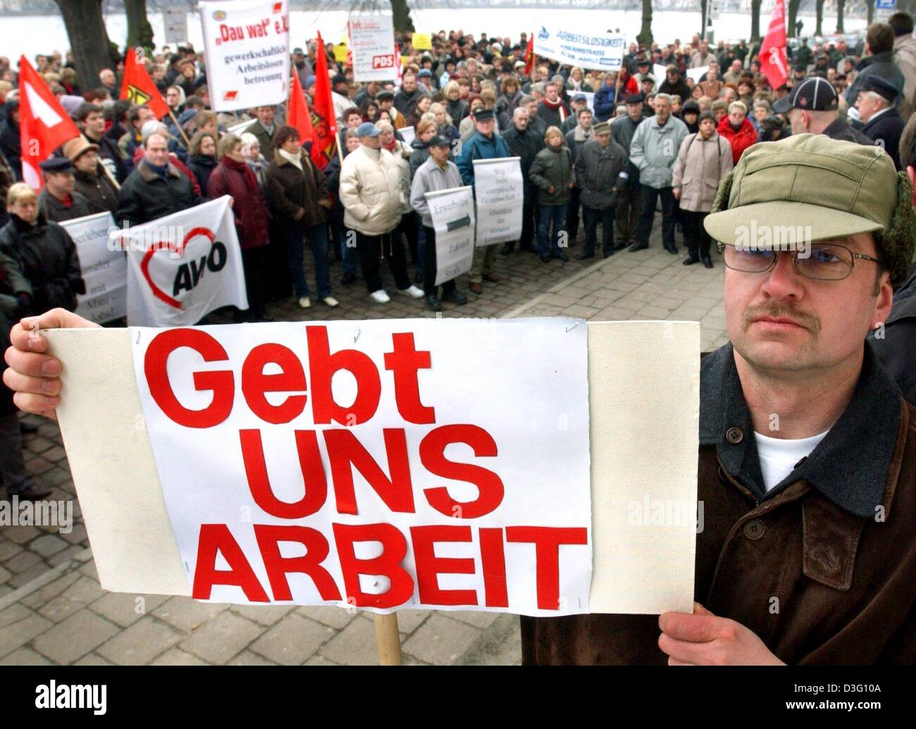 (dpa) - The workless Detlef Bartelt shows a poster reading 'Gebt uns Arbeit' (give us jobs) during the political Ash Wednesday parade through the streets of Schwerin, eastern Germany, 5 March 2003. A speaker council of the unemployed had called for the protests, to demonstrate against further job cuts in the German economy. Stock Photo