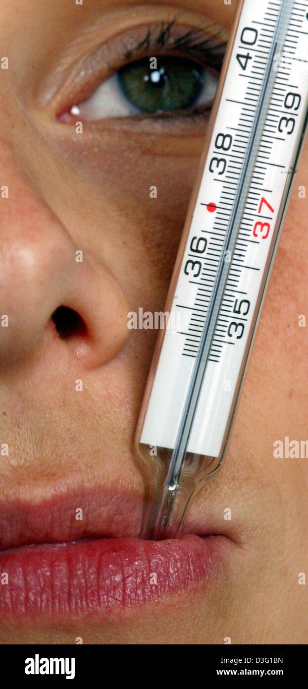 (dpa) - A woman sick with the flu takes her temperature with a thermometer which indicates more than 40 degrees Celsius, in Frankfurt, 28 February 2003. Stock Photo