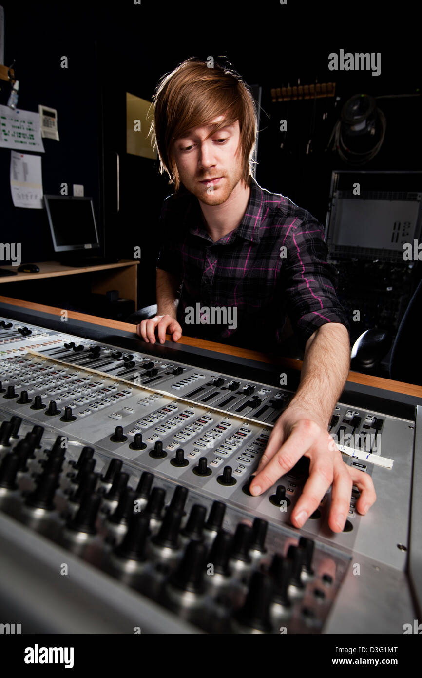 Sound engineer using a studio mixing desk. Selective focus on Sound desk. Stock Photo