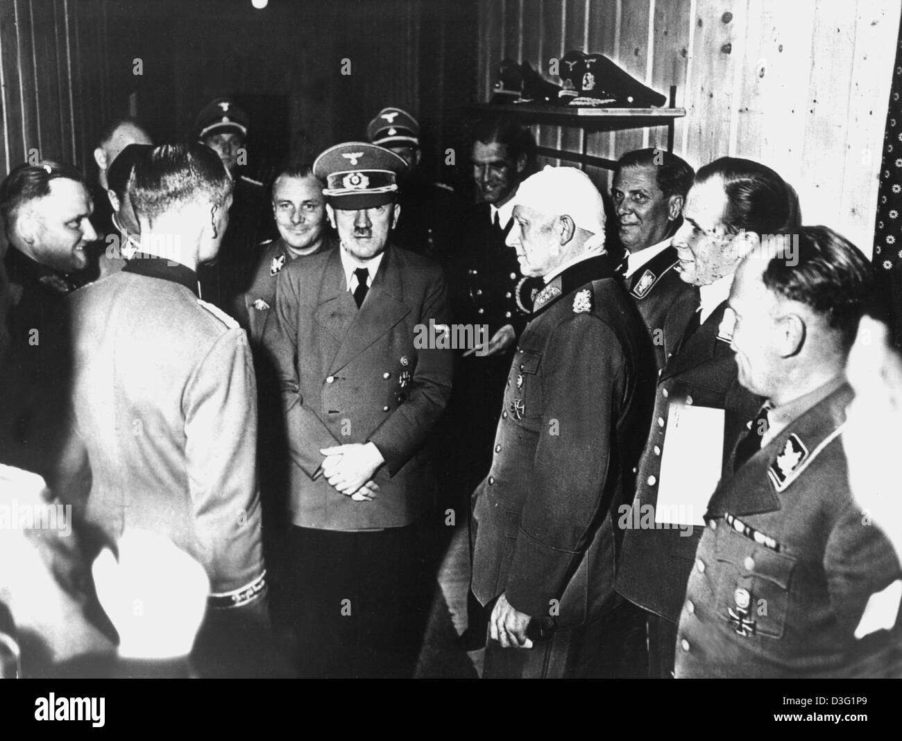 (dpa files) - The picture shows Adolf Hitler standing surrounded by officers after a failed assissination attempt in the bunker at the command headquarters in Rastenburg, Germany, 20 July 1944. To the left behind Hitlaer stands his adjutant Martin Bormann and to the right stands Chief of Army Operations General Alfred Jodl with a bandage around his head. Stock Photo