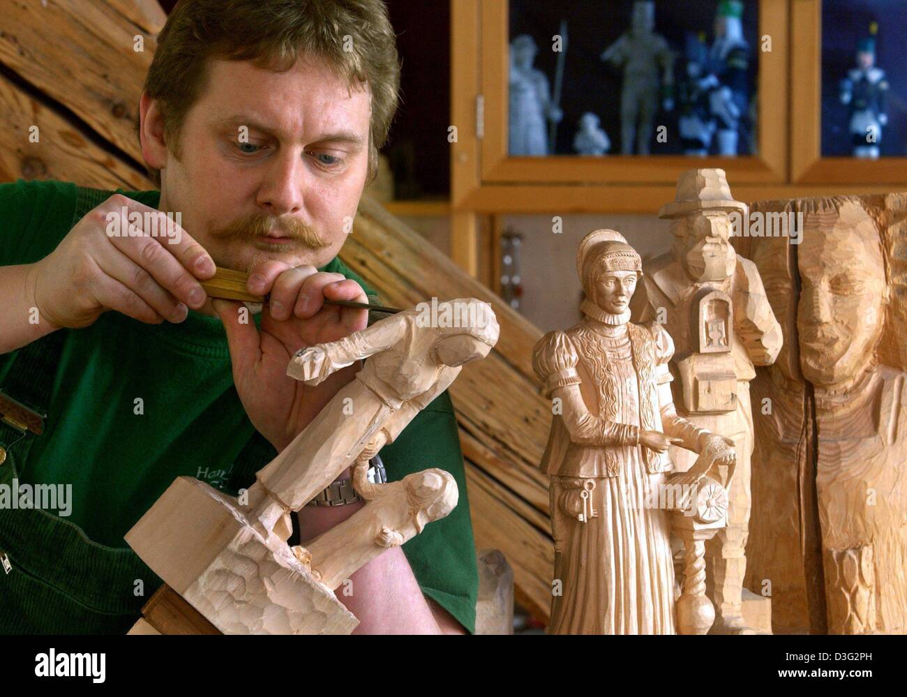 (dpa) The wood carver Volker Kraemer works on a limewood figure of