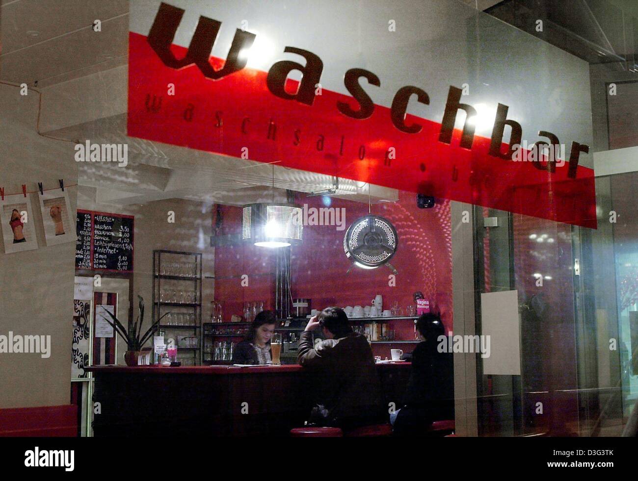 (dpa) - Customers and visitors sit at a bar at a launderette in Ruesselsheim, Germany, 18 February 2003. A lamp in the shape of a washing mashine barrel is hanging down from the ceiling. Above the bar hangs a sign which reads 'Washbar'. Local artists have been running the launderette, the 'Waschbar', for almost two years. It also functions as an exhibition space for their works of  Stock Photo