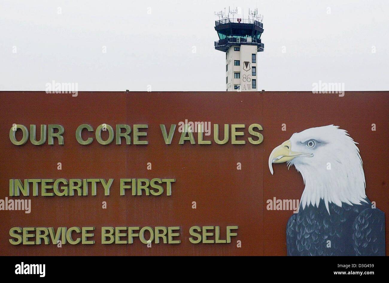 (dpa) - The airport tower protrudes behind a monument with the slogan of the US airbase Ramstein near Landstuhl, western Germany, 10 February 2003. Ramstein is the biggest base of the US air force outside the United States. It is the home of the 86th airlift wing (transportation squadron) and the headquarter of the US Air Forces Europe. According to the newspaper 'Welt am Sonntag'  Stock Photo