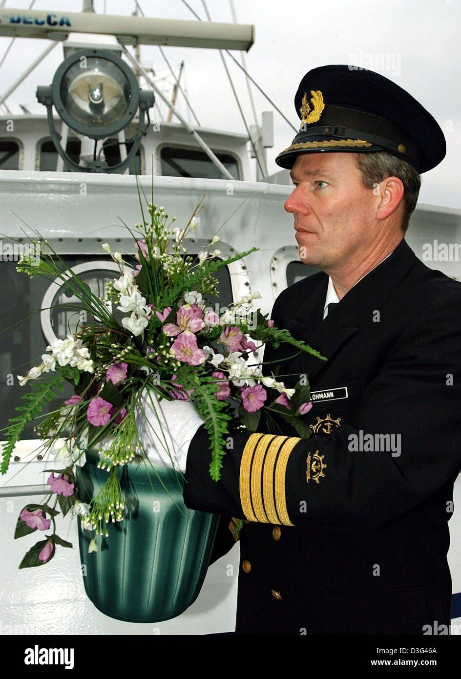 (dpa) Bernd Lohman carries a potted flower arrangement during a