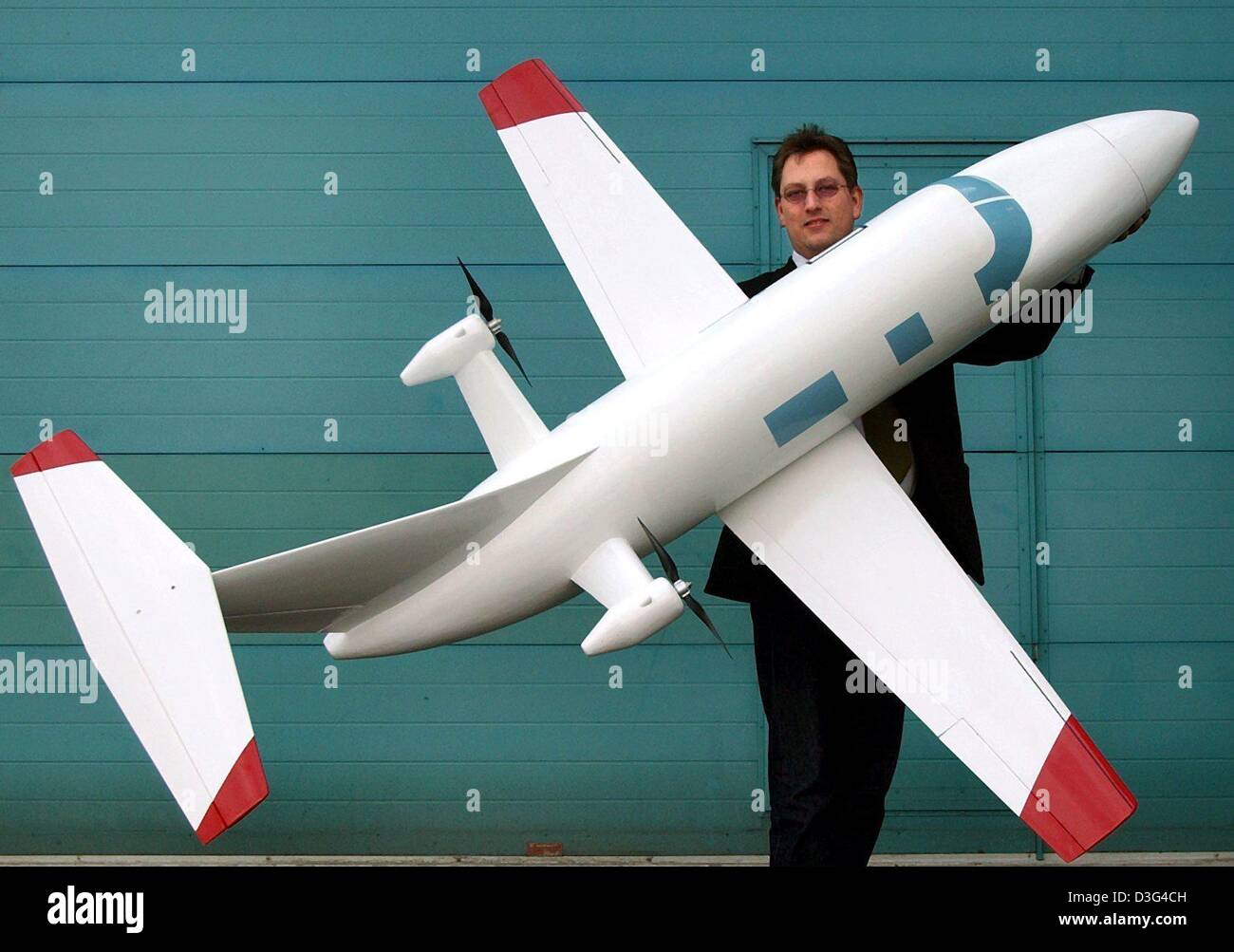 (dpa) - Christian Majunke, chief designer of the company High Performance Aircraft, presents the model for a new commercial airplane at the company's headquarters in Kritzow, Germany, 28 January 2003. The plane seats four passengers and one pilot. The two rotors are attached to the rear of the plane and are powered by one V8 diesel engine, which reduces the petrol consumption by ha Stock Photo
