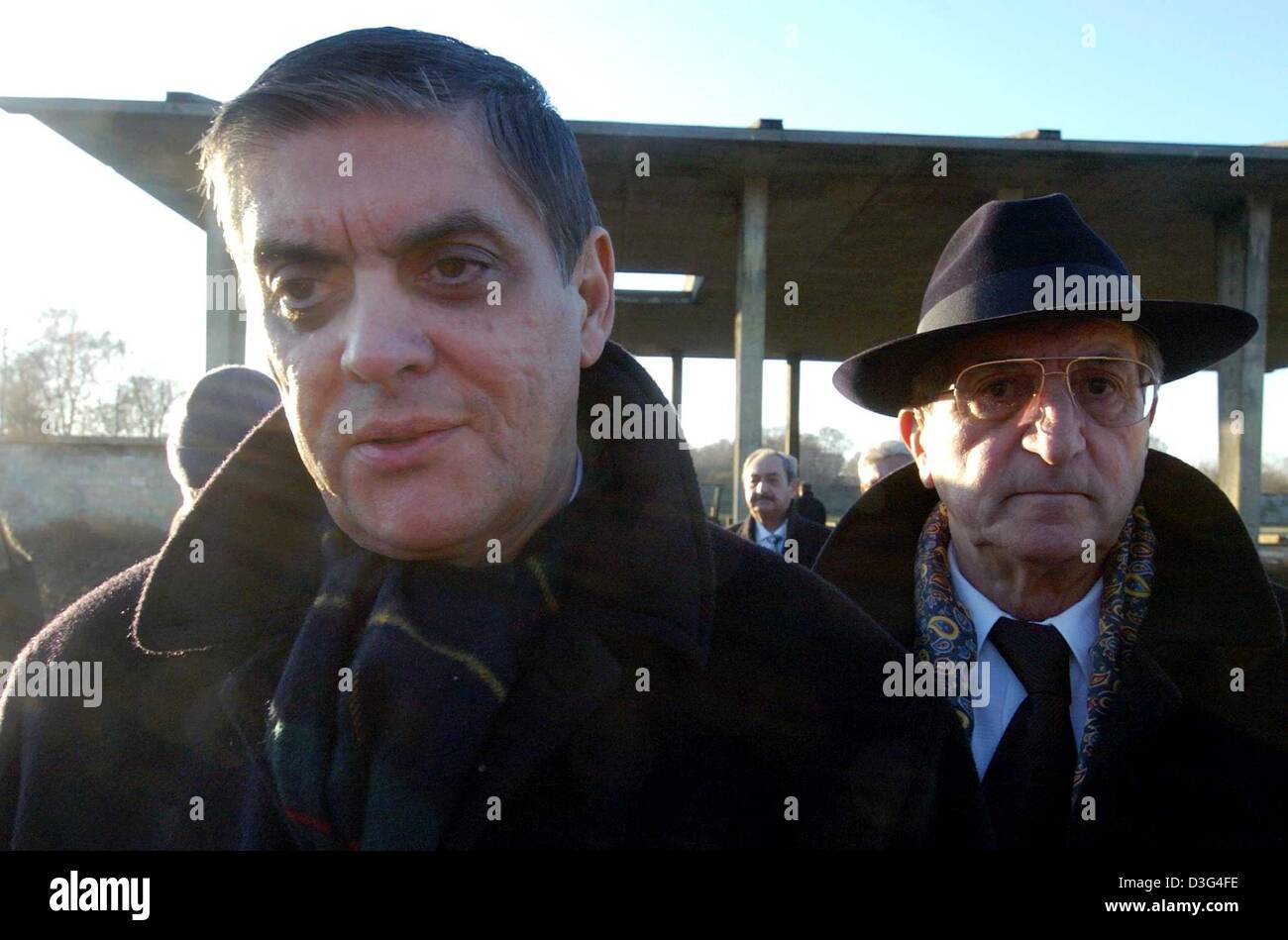 (dpa) - Romani Rose, Chairman of the Central Consistory of Sinti and Roma in Germany, and Walter Stanowski Winter, a survivor of the Nazi concentration camp in Auschwitz, walk past the crematory at the former Nazi concentration camp Sachsenhausen in Oranienburg, Germany, 18 December 2003. The day marks the 61st anniversary of the Auschwitz decree, which sealed the destiny of thousa Stock Photo