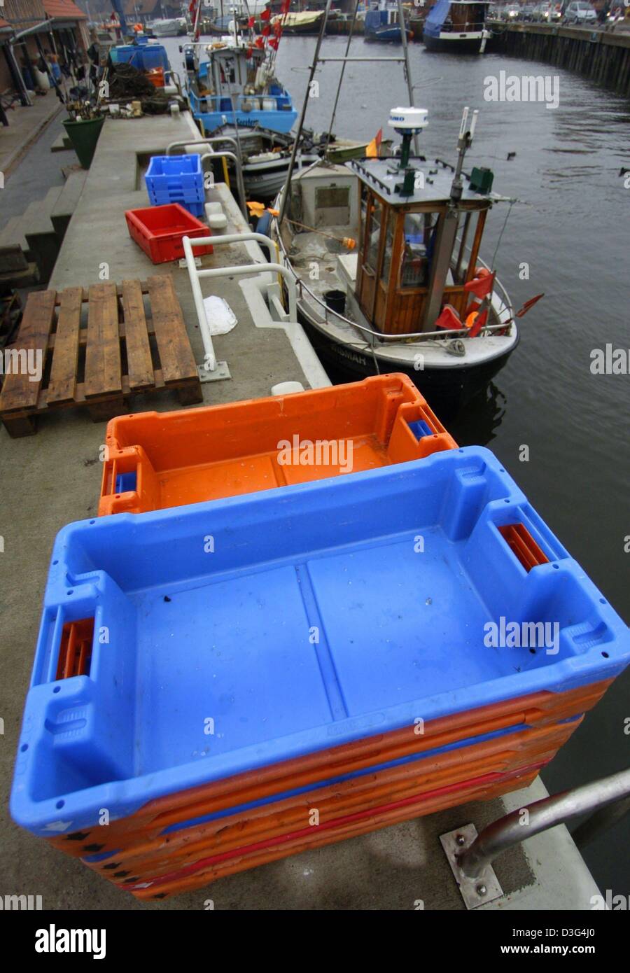 (dpa) Empty fish boxes are piled up in the harbour in Wismar, Germany