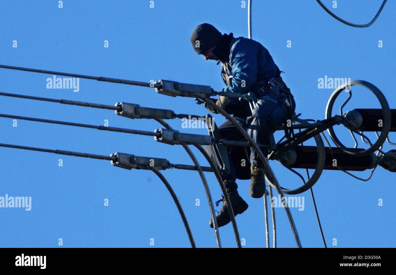 (dpa) - Working on power lines requires a good head for heights, pictured in Hattersheim, Germany, 9 December 2003. Specialists are working in heights of up to 50 metres to fix the thick steel cables. Stock Photo