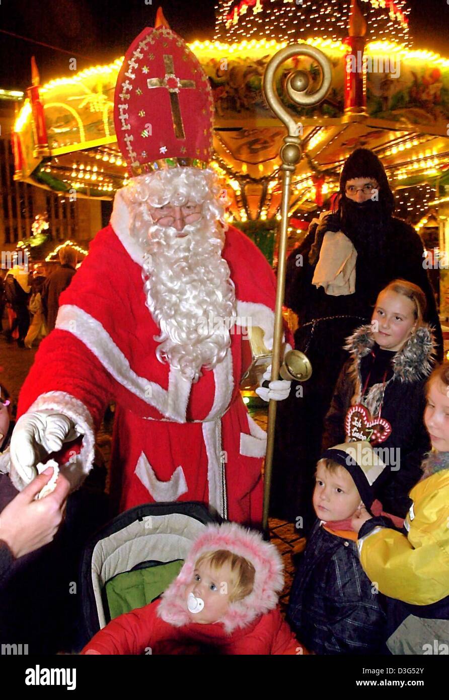 (dpa) - Heinz-Juergen Preuss is dressed as Saint Nicolaus on the Christmas market in Dortmund, Germany, 25 November 2003. The original Father Christmas is Saint Nicolaus from Turkey, who lived ca 300 years after Christ. As a bishop in Myra, he is known as a person who often helped people (especially children) in distress. Because he was so good and helped young people in need, he h Stock Photo