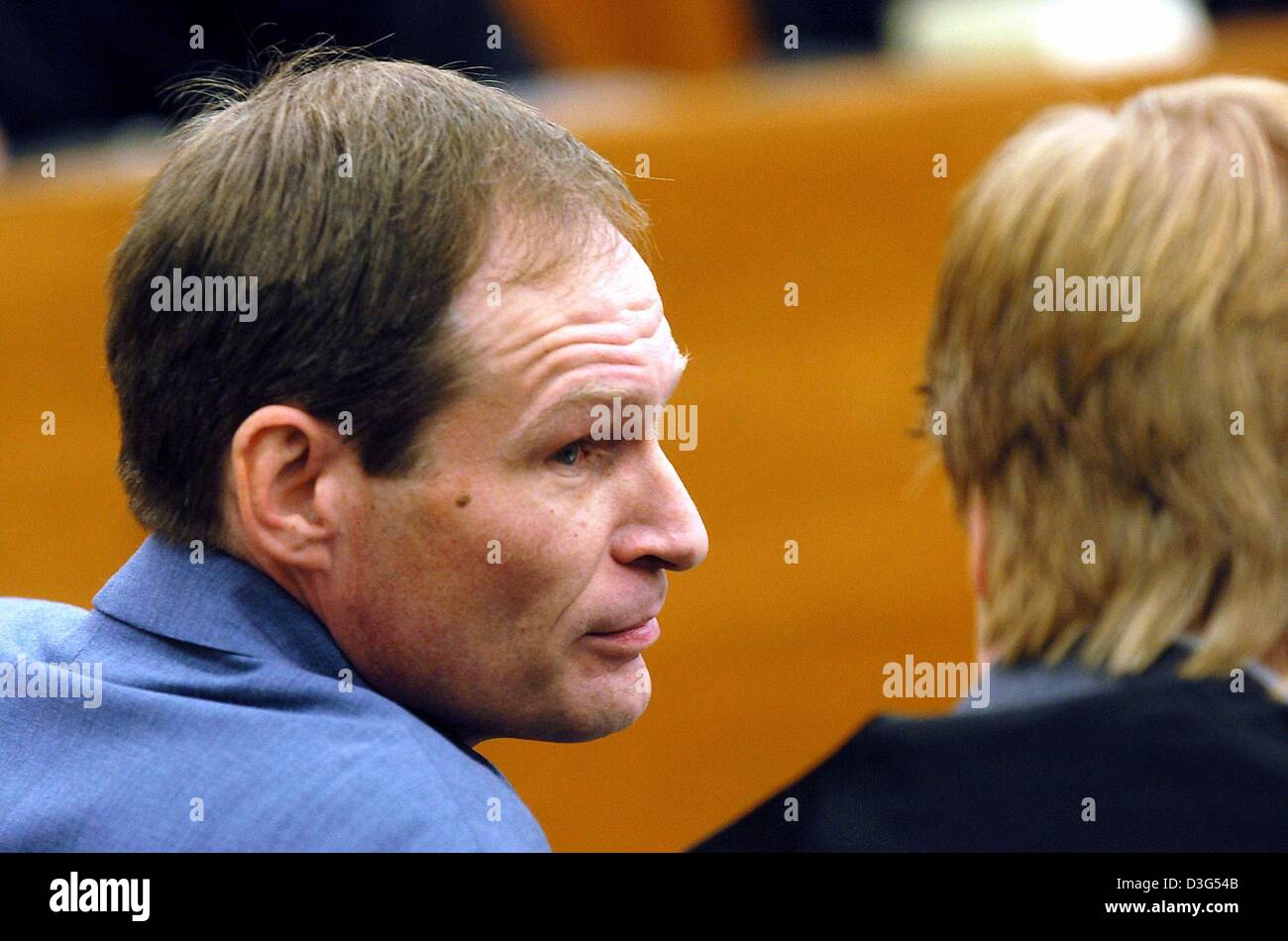 (dpa) - 42-year-old German computer specialist Armin Meiwes looks at his lawyer during the second day of his trial at the district court in Kassel, Germany, 8 December 2003. The court was set to view video tapes showing how the self-declared cannibal killed, cut up and ate his victim. The second day of the murder trial of Meiwes began with evidence to be given by police who visited Stock Photo