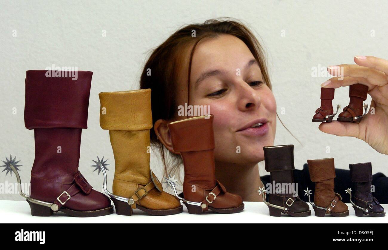 (dpa) - Wiebke Gloeckner looks at minature boots at the museum Burg Mildenstein in Leisnig, Germany, 2 December 2003. The smallest boot measures 1.7 cm in length and 3.1 cm in height, while the biggest of the eight boots is 10 cm long and 20 cm high. The boots were manufactured by shoemaker Gerhard Berthold in 1980. Stock Photo