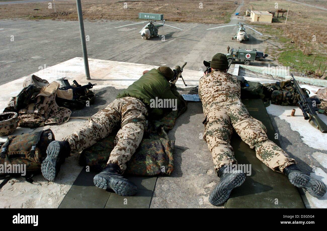 (dpa) - A team of snipers lying on the rooftop of the tower guard the airport in Kundus, Afghanistan, 29 November 2003. The building is guarded by paratroopers, who are also in charge to run the airport. Kundus is one of four Afghan provinces guarded by the German federal armed forces. In the coming month the number of soldiers will be increased to 250. The German camp is still bui Stock Photo