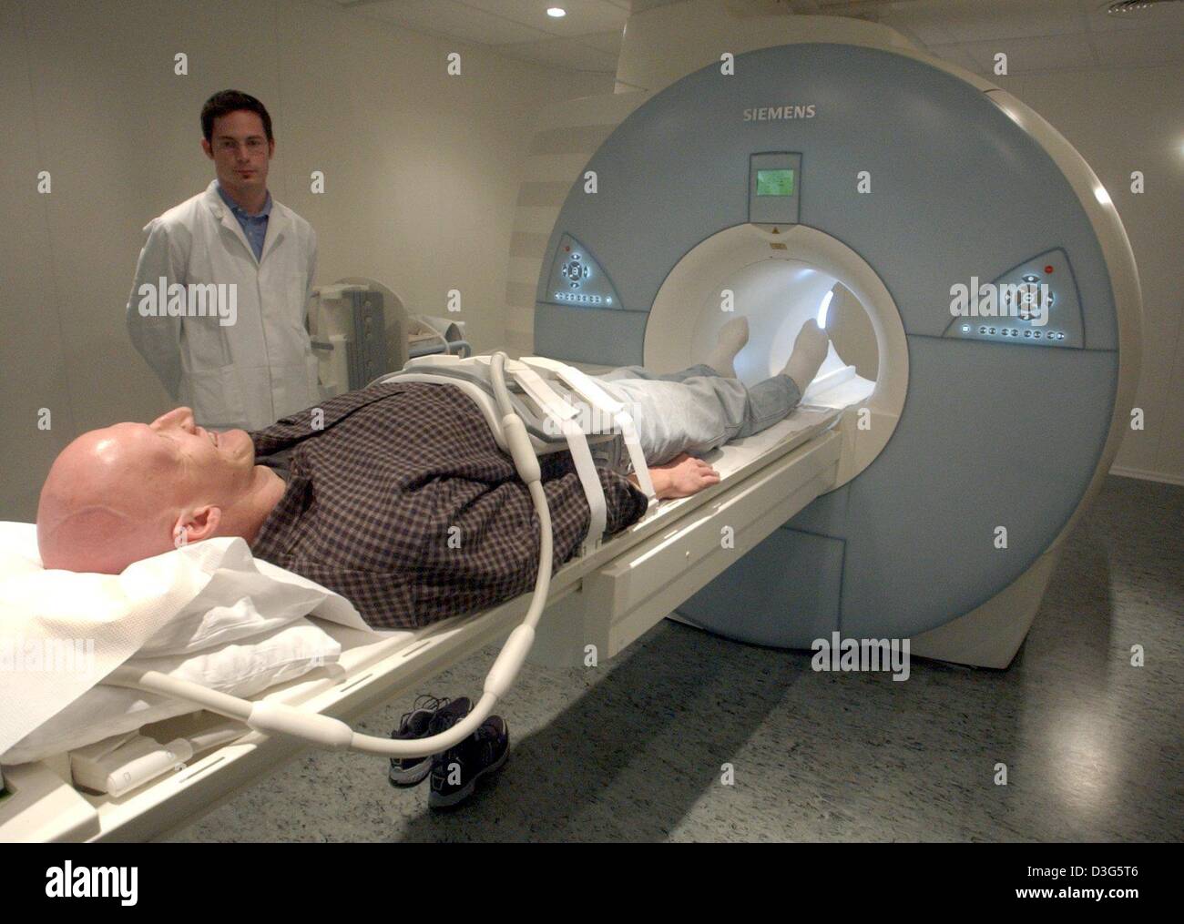 (dpa) - The worldwide first magnetic resonance tomograph for full-length magnetic resonance imaging (MRI) scans is presented by Siemens at the university in Tuebingen, Germany, 25 November 2003. On the left doctor Michael Fenchel. Stock Photo