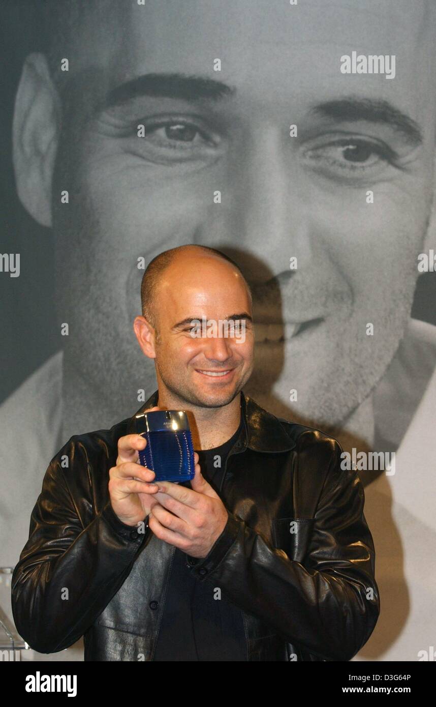 (dpa) - US tennis pro Andre Agassi stand in front of an oversized portrait of himself and smiles as he present a bottle of his new fragrance for man called 'Aramis Life' in Munich, Germany, 19 November 2003. Agassi will be throughout the next few years the advertising front man for the fragrance and the cosmetics series produced by 'Aramis and Designer Fragrances' . Stock Photo