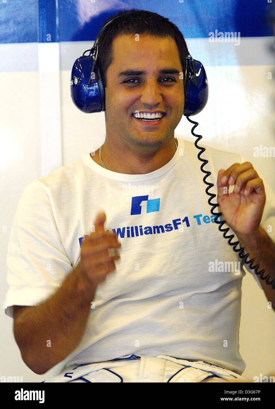 (dpa) - Colombian Formula One pilot Juan Pablo Montoya of BMW Williams smiles as he wears a set of headphones and sits in the pit during the second free practice round for the Formula One Hungarian Grand Prix on the Hungaroring circuit, near Budapest, Hungary, 23 August 2003. Montoya will drive the 2005 formula one season for the team of McLaren-Mercedes. The German-British team of Stock Photo