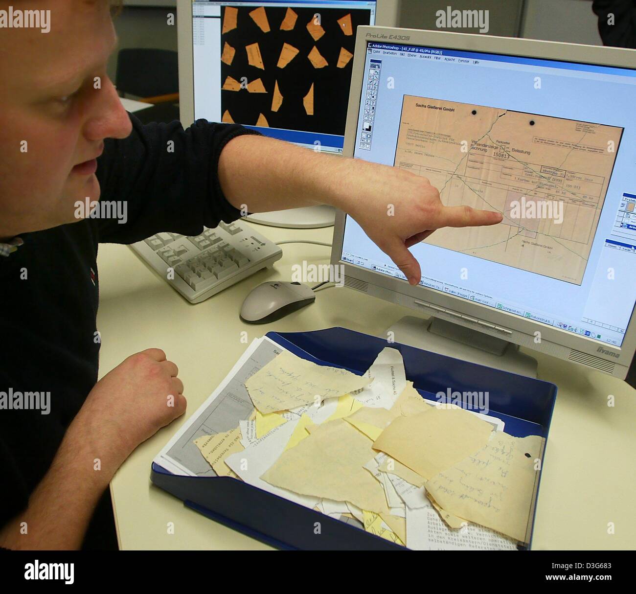 (dpa) - Ottmar Buennemeyer, an employee of the Frauenhofer Institute, explains on a computer screen the procedure of reconstructing shredded Stasi document during a press conference in Berlin, 17 November 2003. A recognition software was developed in co-operation with Lufthansa Systems, which is able to automatically join the pieces of paper which belong together. The documents whi Stock Photo