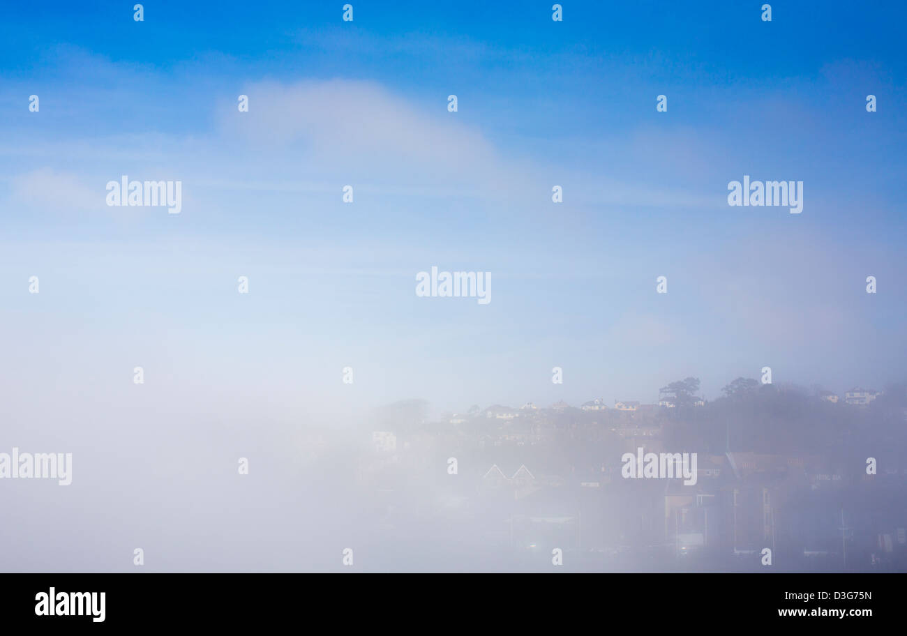 The town of Clevedon, Somerset is shrouded in sea mist and fog on an otherwise sunny blue sky day in the spring. Stock Photo
