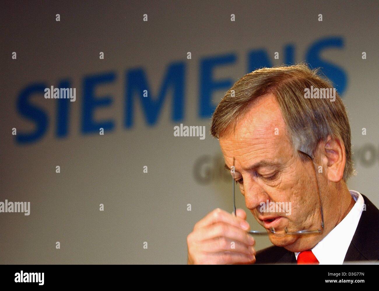 (dpa) - Heinrich von Pierer, CEO of the German electrotechnology giant Siemens, takes off his glasses during the annual press conference in Munich, 13 November 2003. Siemens net earnings in the fiscal year 2003 dropped slightly to 2.44 billion euros, compared with 2.6 billion euros the year before. Turnover in the latest business year was 74.2 billion euros, down 12 per cent from 2 Stock Photo